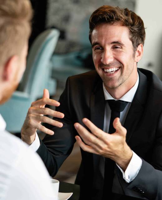 Colleagues and friends. Two cheerful businessmen having coffee break and talking to each other