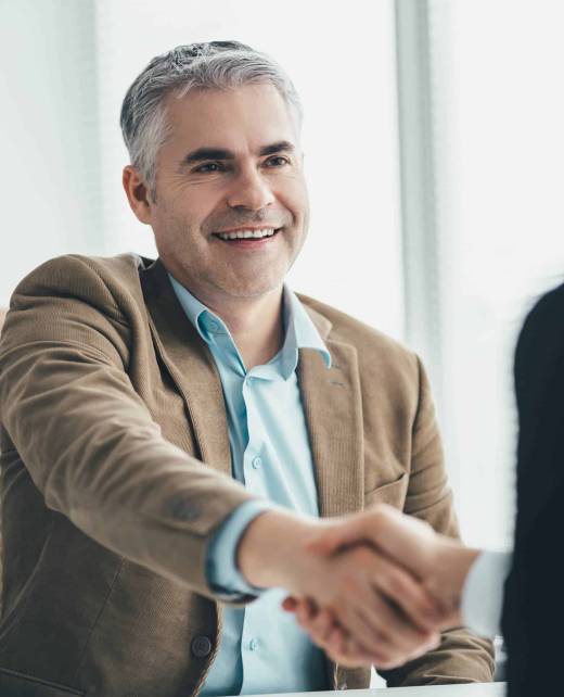 The two businessmen handshaking in the office The two businessmen handshaking in the office